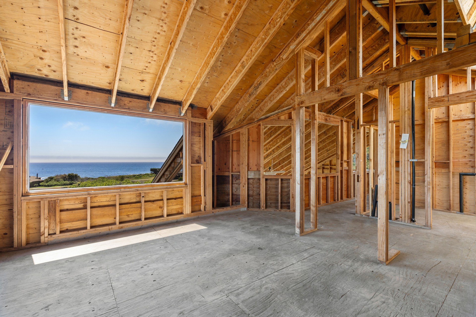 Home interior with wood framing under construction and ocean view